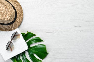 Beyaz ahşap arka planda güneş gözlüğü ve şapka. Üst Manzara. Boş kopyalama alanı.