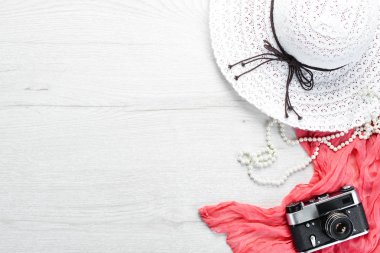 Beyaz ahşap arka planda güneş gözlüğü, kamera ve şapka. Tatil konsepti. Üst Manzara. Boş kopyalama alanı.