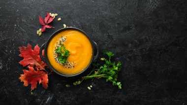 Sonbahar kompozisyonu: kabaklı balkabağı çorbası ve renkli sonbahar yaprakları. Düz yat. Beyaz ahşap bir arka planda. Üst Manzara. Metnin için boş yer.