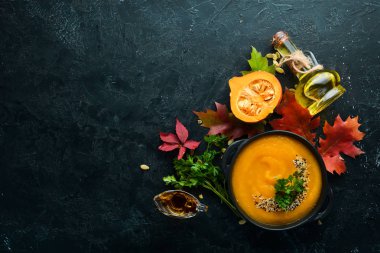 Sonbahar kompozisyonu: kabaklı balkabağı çorbası ve renkli sonbahar yaprakları. Düz yat. Beyaz ahşap bir arka planda. Üst Manzara. Metnin için boş yer.