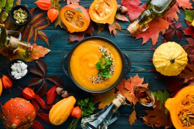 Sonbahar kompozisyonu: kabaklı balkabağı çorbası ve renkli sonbahar yaprakları. Düz yat. Beyaz ahşap bir arka planda. Üst Manzara. Metnin için boş yer.