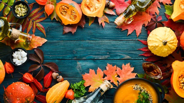 Autumn background with coffee, pumpkin, autumn leaves. flat lay. On a blue wooden background. Top view. Free space for your text.