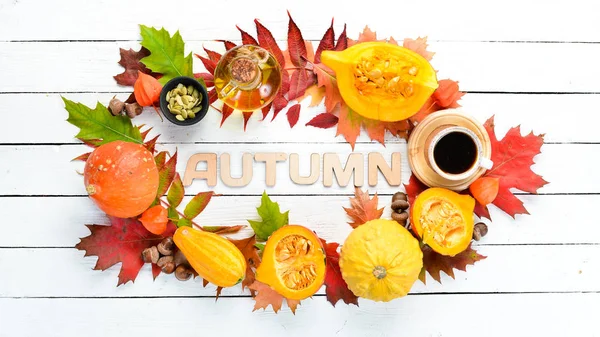 Autumn background with coffee, pumpkin, autumn leaves. flat lay. On a white wooden background. Top view. Free space for your text.