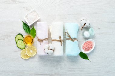 Spa mı? Havlular, yüz kremi, tropik yapraklar. Beyaz ahşap bir arka planda. Düz yatıyordu.