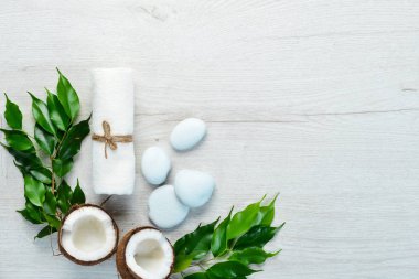 Spa mı? Havlular, yüz kremi, tropik yapraklar. Beyaz ahşap bir arka planda. Düz yatıyordu.