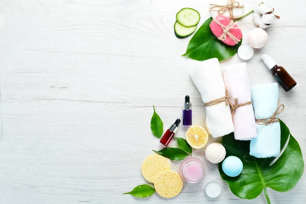 Een Spa Handdoeken Gezichtscrème Tropische Bladeren Een Witte Houten Achtergrond — Stockfoto