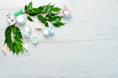 Doğal yüz kremi. Yüz bakımı. Beyaz ahşap bir arka planda. Düz yatıyordu.