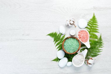 Aromatik renkli deniz tuzu beyaz ahşap bir masada. Kozmetik ve spa konsepti. Üst Manzara. Boş kopyalama alanı.