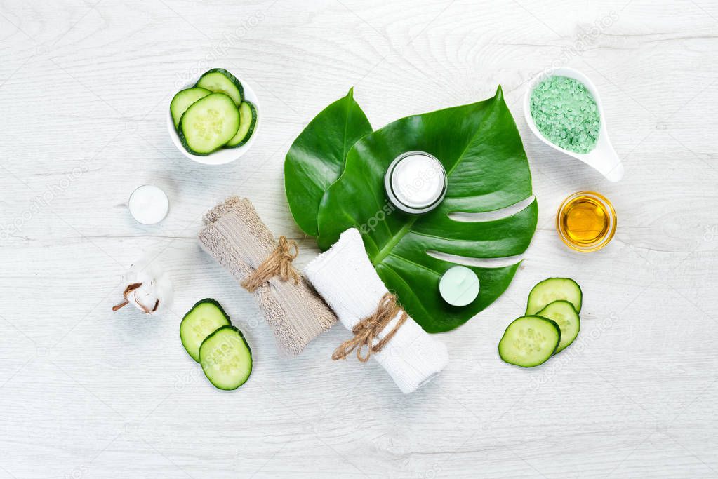 Natural cosmetics from green cucumber, on white wooden background. The concept of cosmetics and spa. Top view. Free copy space.