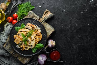 Beyaz ahşap arka planda siyah bir tabakta susamlı ve fesleğenli kızarmış mantar. Üst Manzara. Metnin için boş yer.