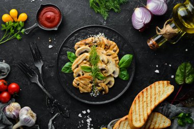 Beyaz ahşap arka planda siyah bir tabakta susamlı ve fesleğenli kızarmış mantar. Üst Manzara. Metnin için boş yer.