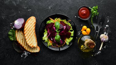 Siyah arka planda siyah tabakta soğanlı pancar salatası. Üst Manzara. Metnin için boş yer.