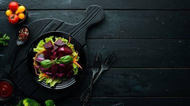 Siyah arka planda siyah tabakta soğanlı pancar salatası. Üst Manzara. Metnin için boş yer.