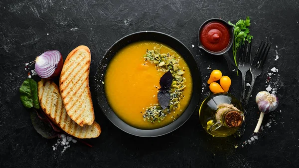 Sopa Calabaza Con Semillas Calabaza Plato Negro Sobre Fondo Madera — Foto de Stock