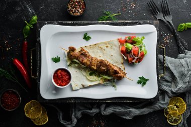 Pita ekmeği ve sebzeli ızgara et şişleri. Et kebabı. Bulaşıklar, yemek. Üst Manzara. Metnin için boş yer.
