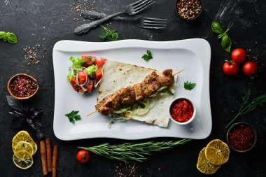 Pita ekmeği ve sebzeli ızgara et şişleri. Et kebabı. Bulaşıklar, yemek. Üst Manzara. Metnin için boş yer.