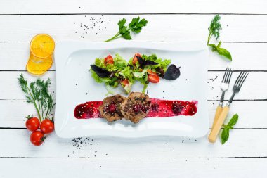 Kiraz soslu dana madalyonu ve sebze. Bulaşıklar, yemek. Üst Manzara. Metnin için boş yer.