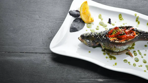 Baked trout stuffed with vegetables. Dishes, food. Top view. Free space for your text.