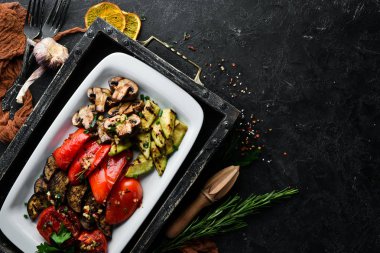 Tabakta ızgara sebze. Domates, patlıcan, mantar, kabak. Bulaşıklar, yemek. Üst Manzara. Metnin için boş yer.