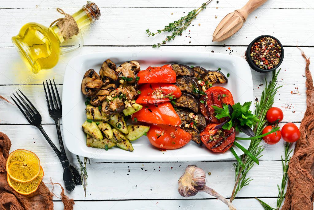 Grilled vegetables on a plate. Tomatoes, eggplants, mushrooms, zucchini. Dishes, food. Top view. Free space for your text.