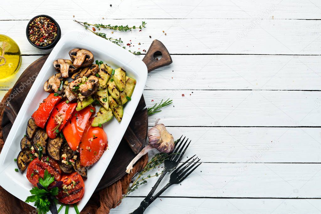 Grilled vegetables on a plate. Tomatoes, eggplants, mushrooms, zucchini. Dishes, food. Top view. Free space for your text.