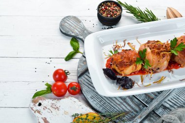 Peynirli ve soslu fırında tavuk bacağı. Bulaşıklar, yemek. Üst Manzara. Metnin için boş yer.