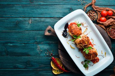 Peynirli ve soslu fırında tavuk bacağı. Bulaşıklar, yemek. Üst Manzara. Metnin için boş yer.