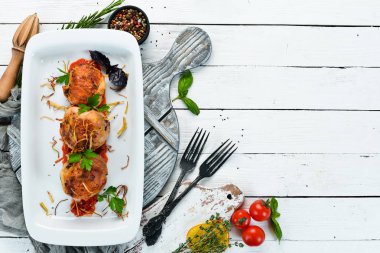 Peynirli ve soslu fırında tavuk bacağı. Bulaşıklar, yemek. Üst Manzara. Metnin için boş yer.