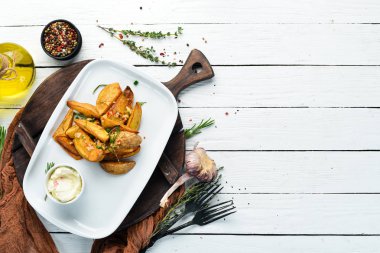 Sarımsaklı ve soslu fırında patates. Bulaşıklar, yemek. Üst Manzara. Metnin için boş yer.