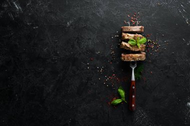 Bir çatalda fırında domuz filetosu. Bulaşıklar, yemek. Üst Manzara. Metnin için boş yer.