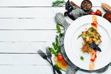 Peynirli fırında domuz bifteği. Bulaşıklar, yemek. Üst Manzara. Metnin için boş yer.