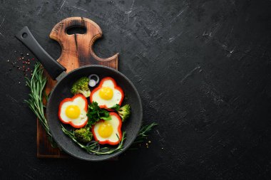 Siyah tabakta tatlı biberli sahanda yumurta. Üst Manzara. Boş kopyalama alanı.