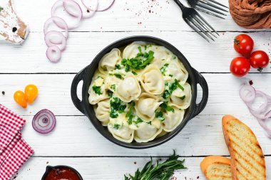 Siyah tabakta krema soslu Ravioli. İtalyan geleneksel mutfağı. Etli börek. Üst Manzara. Boş kopyalama alanı.