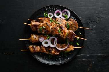 Siyah bir tabakta sulu et şişleri. Barbekü, kebap. Üst Manzara. Boş kopyalama alanı.