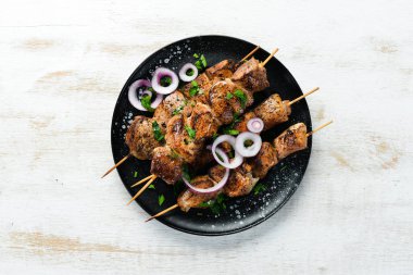Siyah bir tabakta sulu et şişleri. Barbekü, kebap. Üst Manzara. Boş kopyalama alanı.
