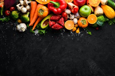 Siyah taş zemin üzerinde taze sebzeler ve meyveler. Sağlıklı yiyecekler. Üst Manzara. Boş kopyalama alanı.