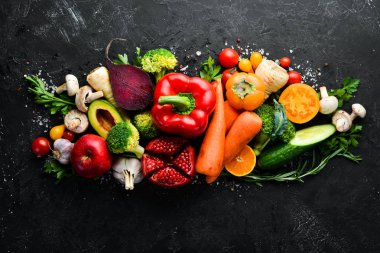 Siyah bir arka planda sonbahar sebzeleri ve meyveler: kabak, domates, mısır, nar, hurma, elma. Üst Manzara. Boş kopyalama alanı.