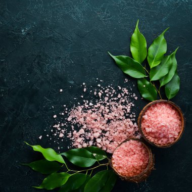 Bir kasede pembe kokulu deniz tuzu. Siyah taştan bir arka planda. Spa tedavileri. Üst Manzara. Metnin için boş yer.