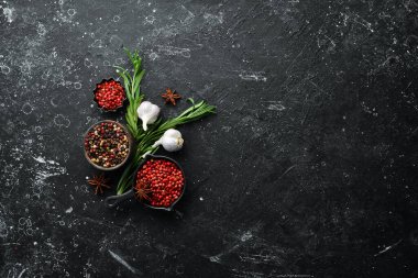 Karanlık bir arka planda çeşitli biber ve baharatlar. Üst Manzara. Metnin için boş yer.