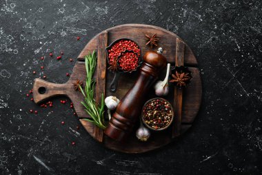 Karanlık bir arka planda çeşitli biber ve baharatlar. Üst Manzara. Metnin için boş yer.