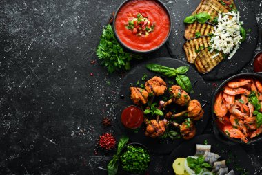 Et, deniz ürünleri ve sebzeleri siyah taş masaya koyun. Üst Manzara. Metnin için boş yer.