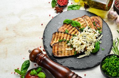 Yiyecekler. Fırında patlıcan, mavi peynirli ve fesleğenli siyah taş tabakta. Üst Manzara. Metnin için boş yer.