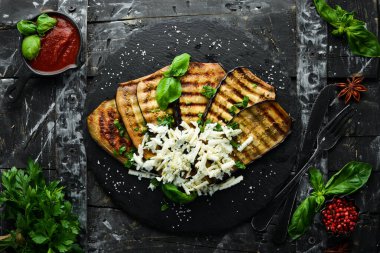 Yiyecekler. Fırında patlıcan, mavi peynirli ve fesleğenli siyah taş tabakta. Üst Manzara. Metnin için boş yer.