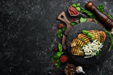 Yiyecekler. Fırında patlıcan, mavi peynirli ve fesleğenli siyah taş tabakta. Üst Manzara. Metnin için boş yer.