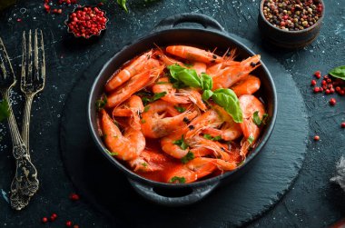 Yiyecekler. Siyah taş tabakta fesleğenli domates soslu haşlanmış karides. Üst Manzara. Metnin için boş yer.
