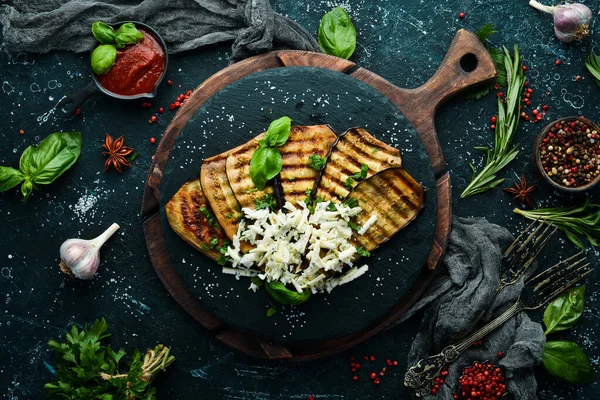 Yiyecekler. Fırında patlıcan, mavi peynirli ve fesleğenli siyah taş tabakta. Üst Manzara. Metnin için boş yer.