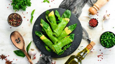 Sağlıklı yiyecekler. Siyah taş tabakta peynirli ve fesleğenli ıspanaklı krep. Üst Manzara. Metnin için boş yer.