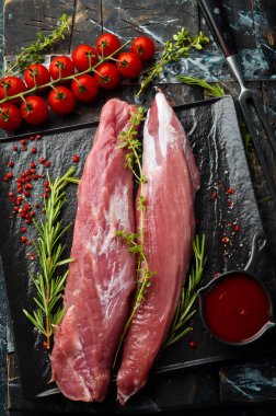 - Et. Siyah taşlı arka planda baharatlı çiğ domuz filetosu. Üst Manzara. Kırsal biçim.