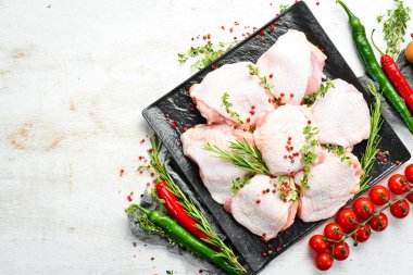 Mutfak arka planında baharat ve malzeme olan çiğ tavuk butları. - Et. Üst Manzara. Kırsal biçim.
