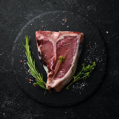 Siyah taştan bir arka planda çiğ biftek. Üst Manzara. Kırsal biçim.